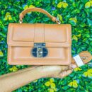 Sac à main marron en cuir avec fermoir metalique